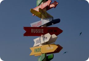 Столб с указателями в виде цветных стрелок с названиями стран